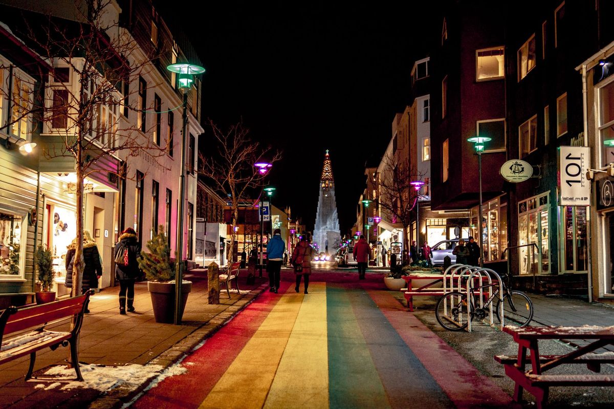 The rainbow-painted street at night, Hallgrímskirkja glowing at its end