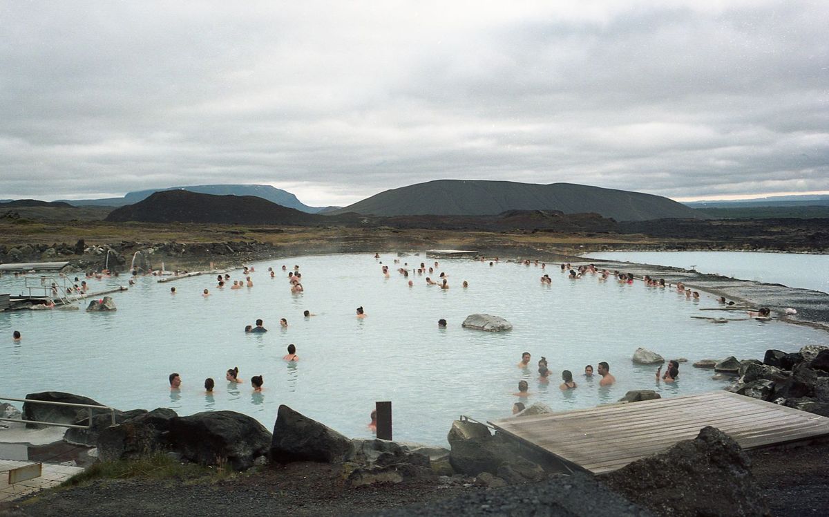 Bathers in a steamy rustic geothermal pool